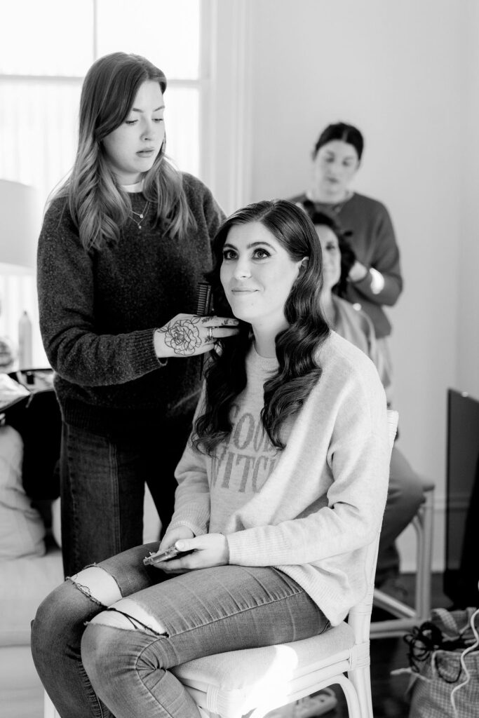 Black and white photo of bride getting her hair styled in the preparation suite at The Bryan Museum in Galveston, Texas