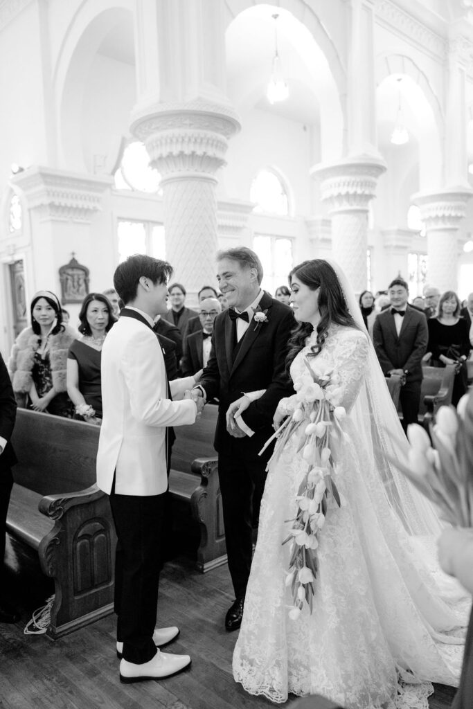 Sacred Heart Catholic Church wedding: Bride and groom with the father of the bride at the altar.