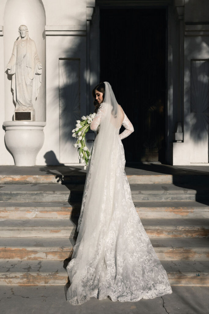 Bride and her beautiful wedding dress train, captured outside the Sacred Heart Catholic Church, before the Bryan Museum wedding.