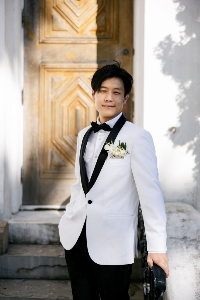 Groom smiling confidently outside Sacred Heart Catholic Church in Galveston before his Bryan Museum wedding ceremony