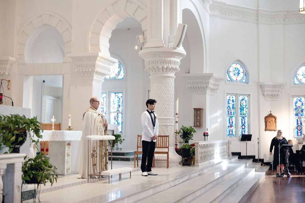 Galveston Catholic wedding: Groom waits for the bride at the altar.