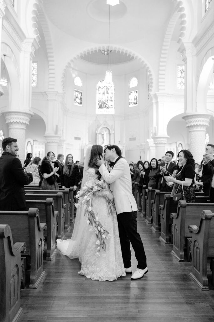 Joyful wedding kiss: Bride and groom at their Galveston church ceremony.