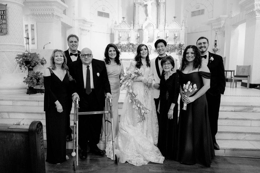 Family photo with the bride and groom, captured at Sacred Heart Catholic Church, before the Bryan Museum wedding.