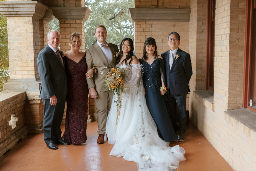 Wedding couple with their parents take a photo at their Bryan Museum garden wedding.