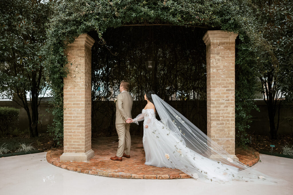 Bride taps groom in a first look at their Bryan Museum garden wedding