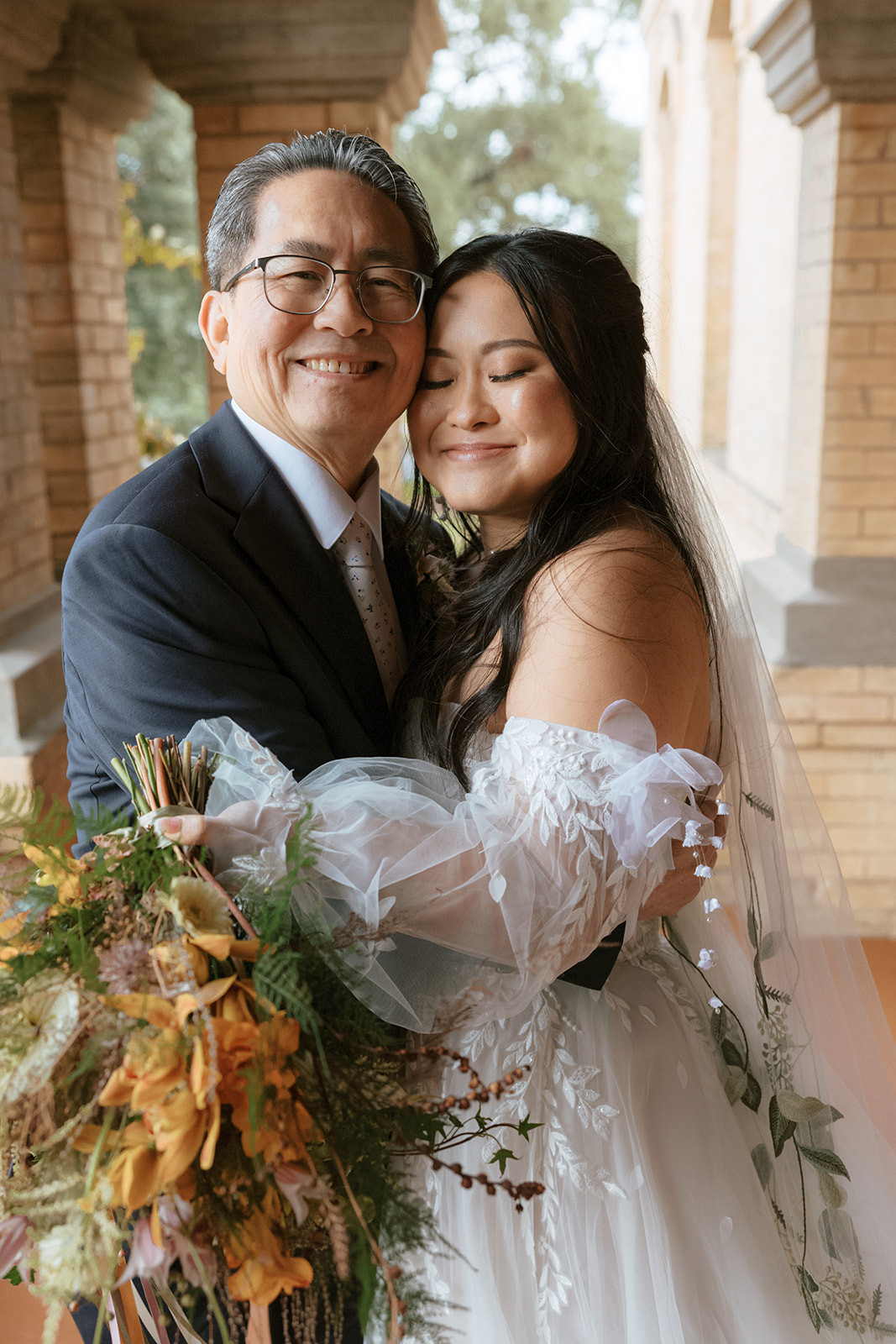 Bride and her father takes a photo at her Bryan Museum garden wedding.