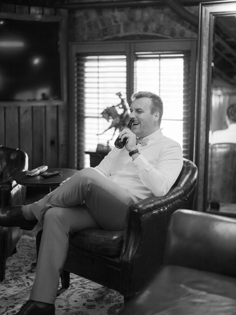 Groom makes a toast on a bottle for his Bryan Museum garden wedding.