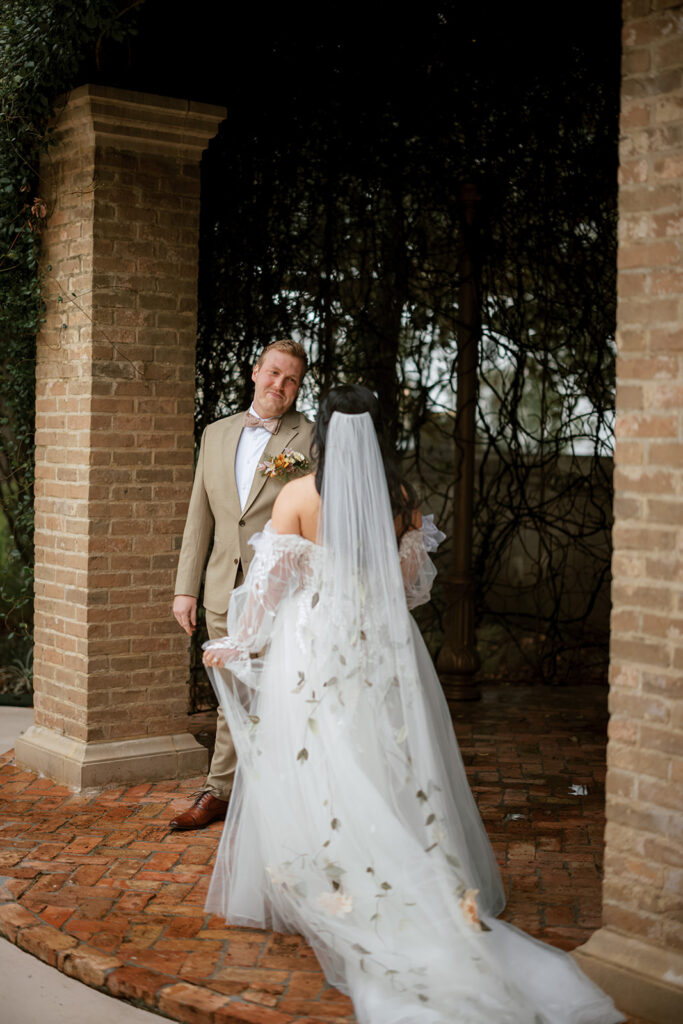 Grroom takes a turn to witness her bride for the first look at their Bryan Museum garden wedding