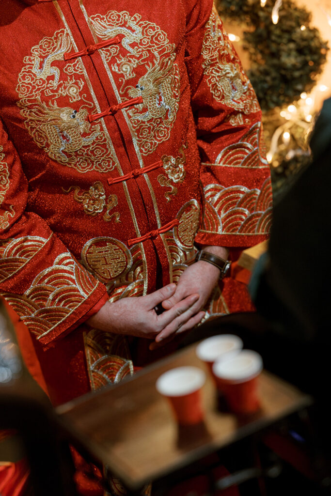 Close-up of Cullen’s hands holding tea cups for the tea ceremony at Bryan Museum garden wedding.