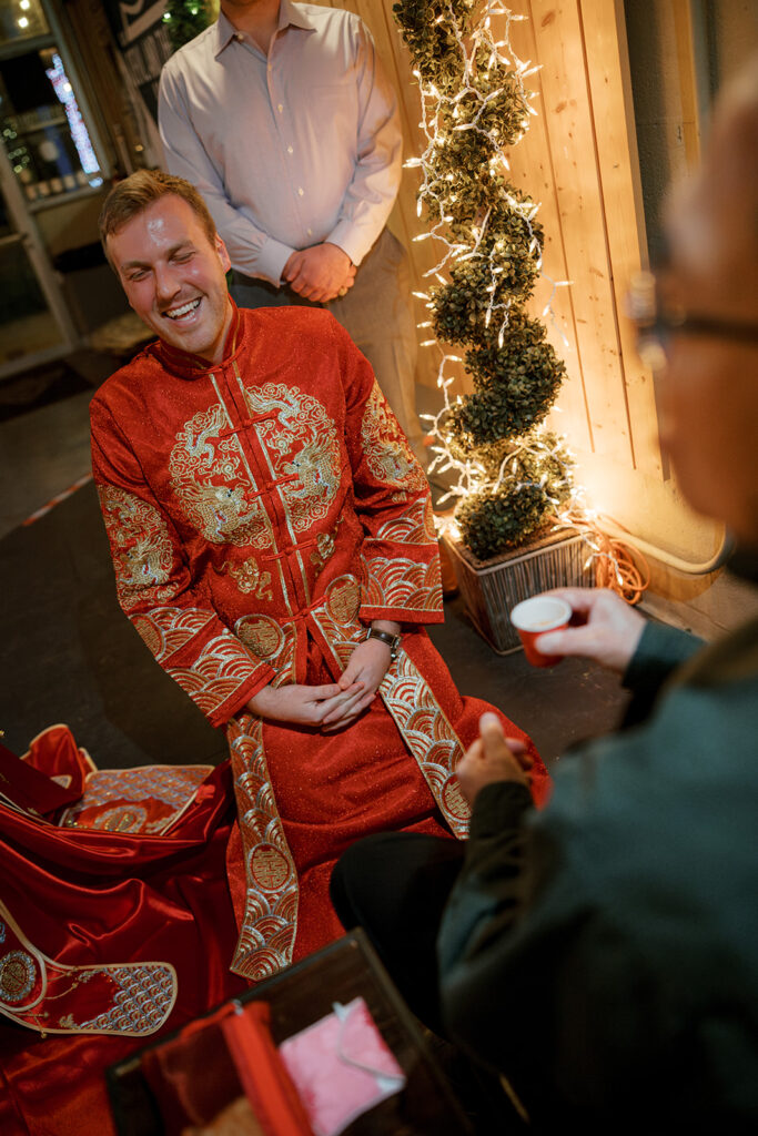 Cullen wearing traditional red embroidered attire during the tea ceremony before their Bryan Museum garden wedding