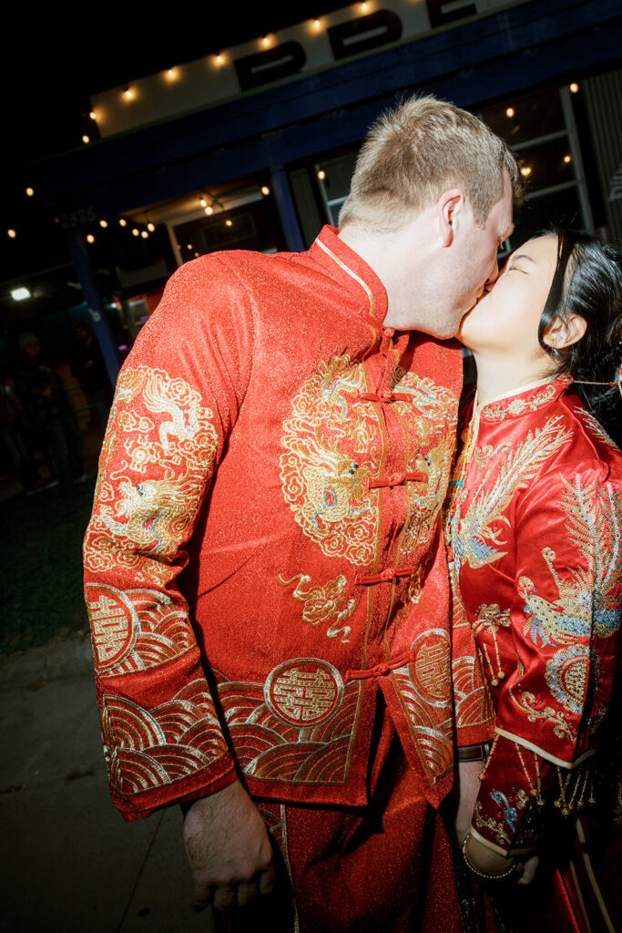 Jessie and Cullen shared a kiss in traditional red and gold outfits during the tea ceremony before their Bryan Museum garden wedding.