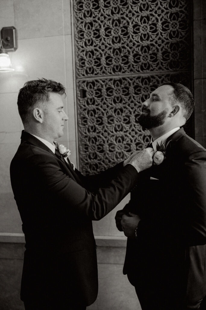 Groomsman helps groom prepare for his Real Wedding at Galveston City National Bank Museum