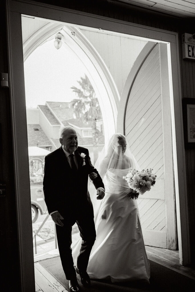 Bride with her father enters the church for her Wedding at Galveston City National Bank Museum
