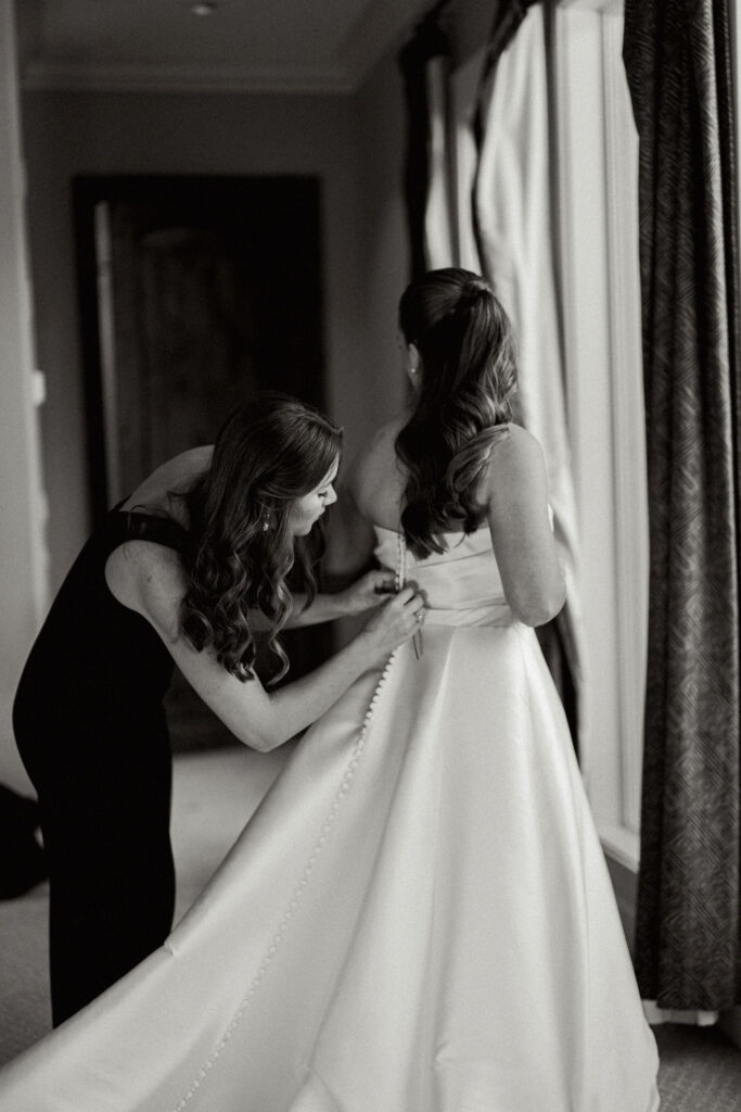 Bride's dress getting buttoned for her Real Wedding at Galveston City National Bank Museum