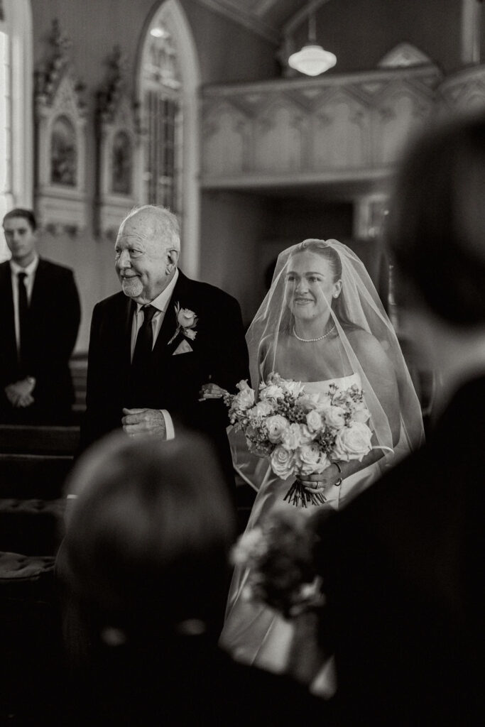 Bride with her father walks the aisle for her Real Wedding at Galveston City National Bank Museum