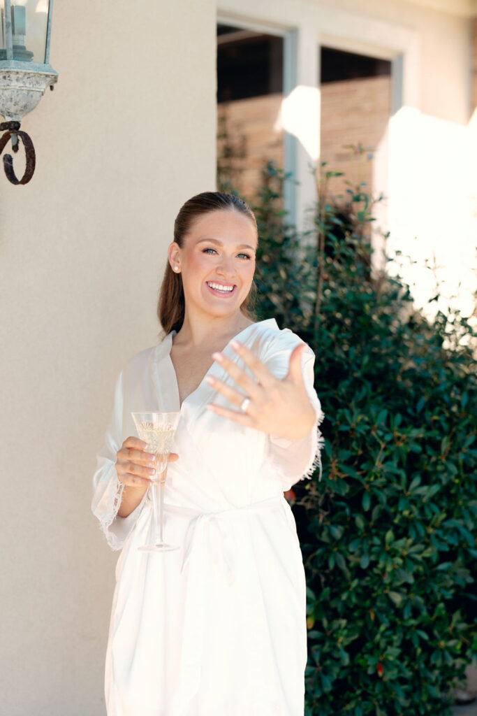 Bride poses showing her ring during her preparations for her real Wedding at Galveston City National Bank Museum.