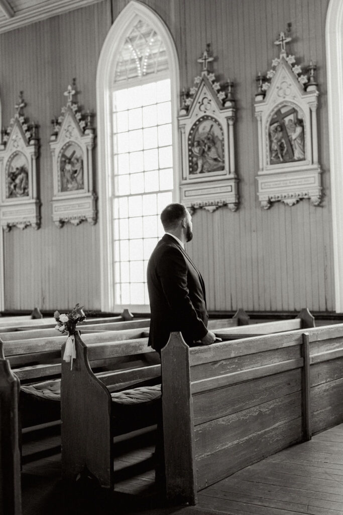 Black and white photo of the groom as he waits for his bride at their Real Wedding at Galveston City National Bank Museum
