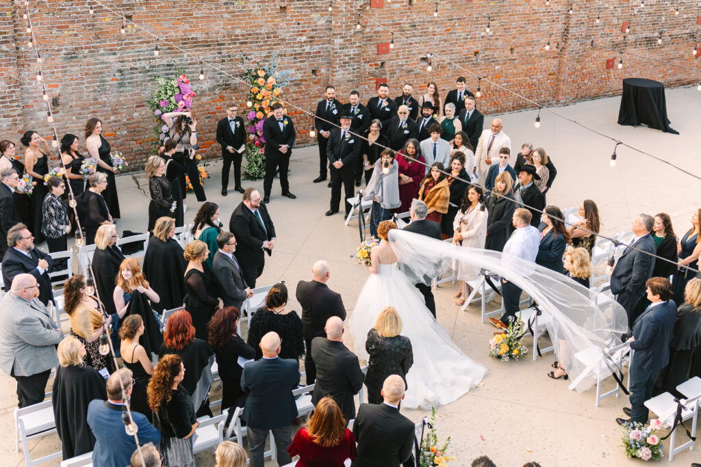 Wide shot of ceremony with guests seated and couple at the altar during a wedding at The Artisan.