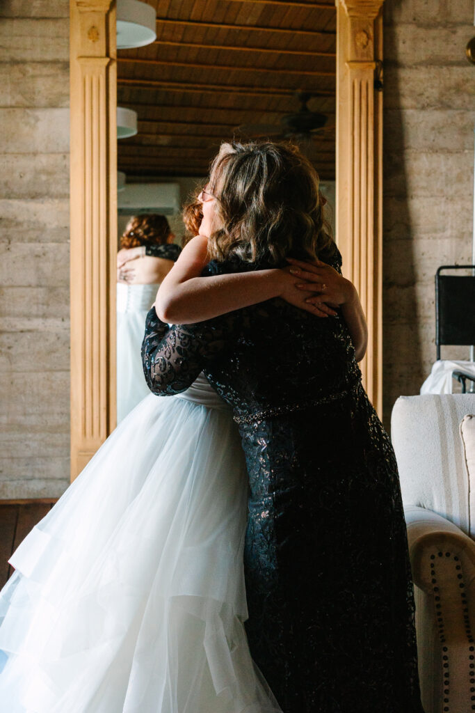 Bride hugging her mother in a candid getting-ready moment at The Artisan.