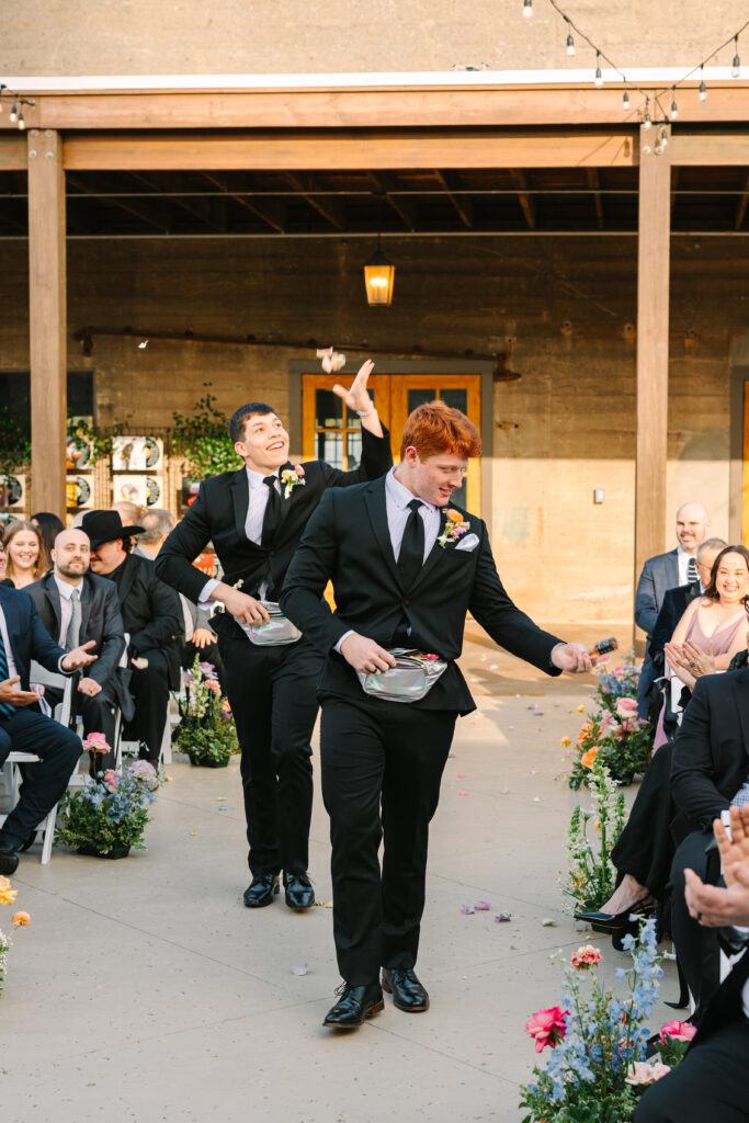 Groomsman walking down the aisle at The Artisan wedding ceremony.