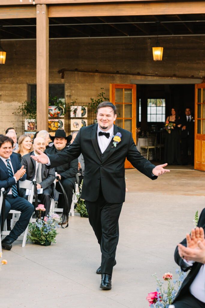 Groom walking down the aisle smiling during a wedding at The Artisan.