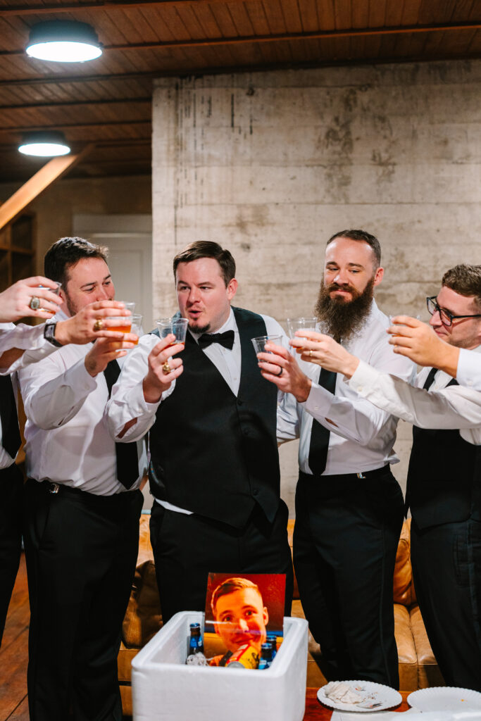 Groomsmen cheering and toasting drinks before the ceremony at The Artisan wedding.