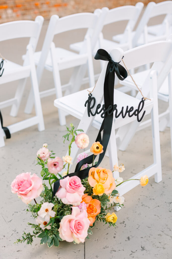 Reserved seating sign with pink floral arrangement for a wedding at The Artisan.