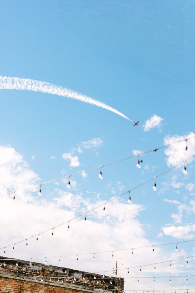 Blue sky with airplane flying overhead during a wedding at The Artisan.