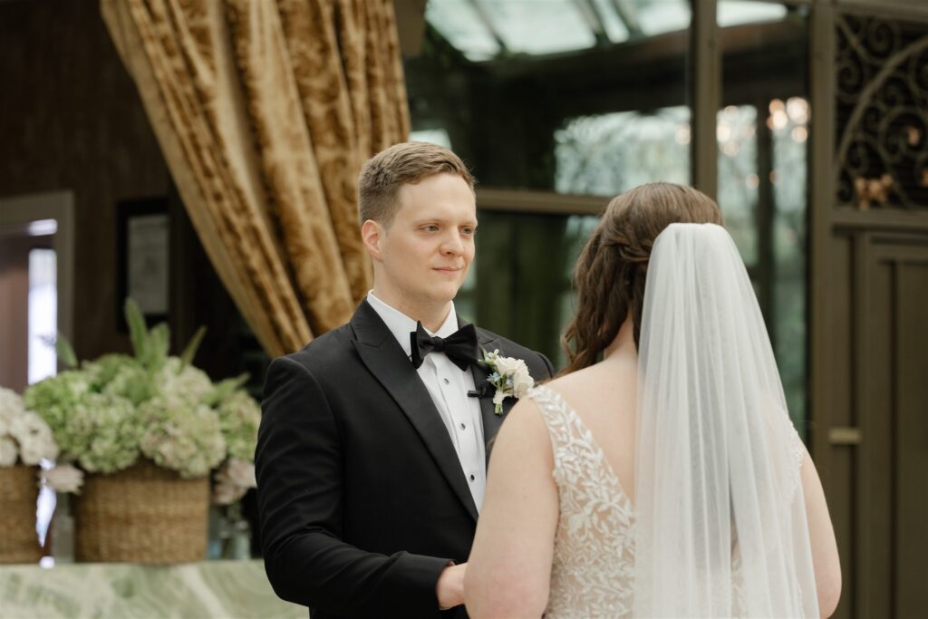Bride and groom sharing their first look in the elegant glass conservatory at The Bryan Museum.