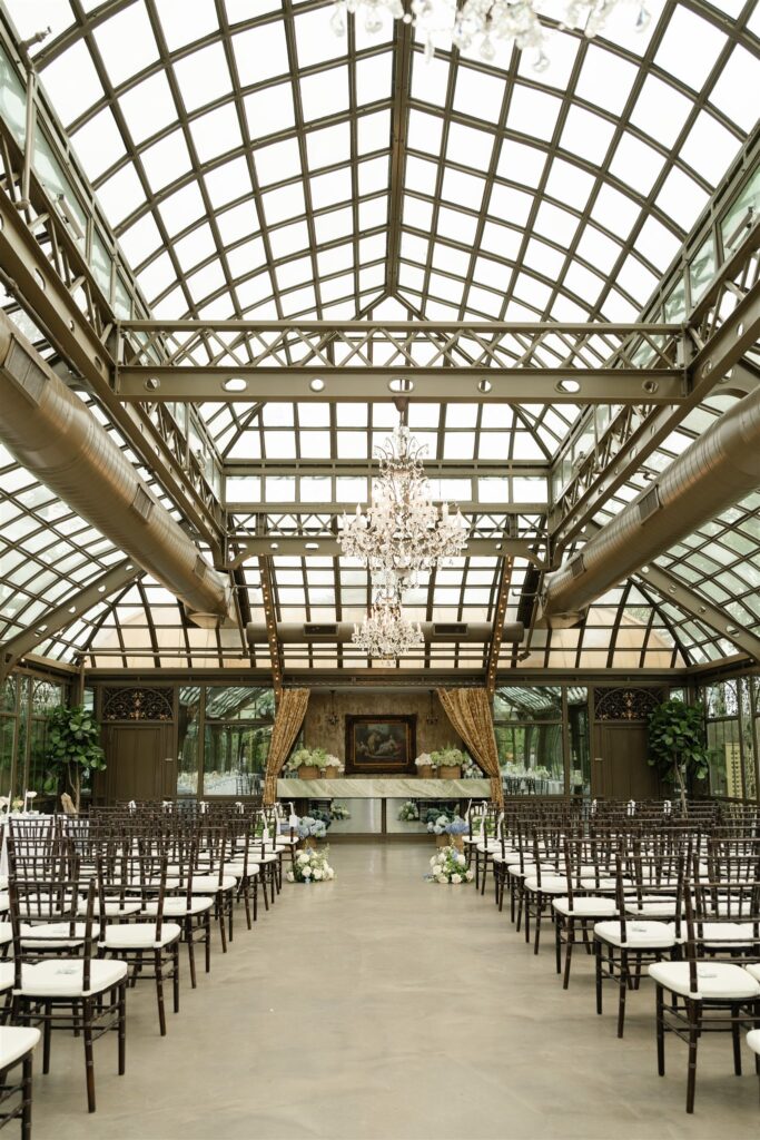 Center aisle view of the glass conservatory wedding ceremony at The Bryan Museum