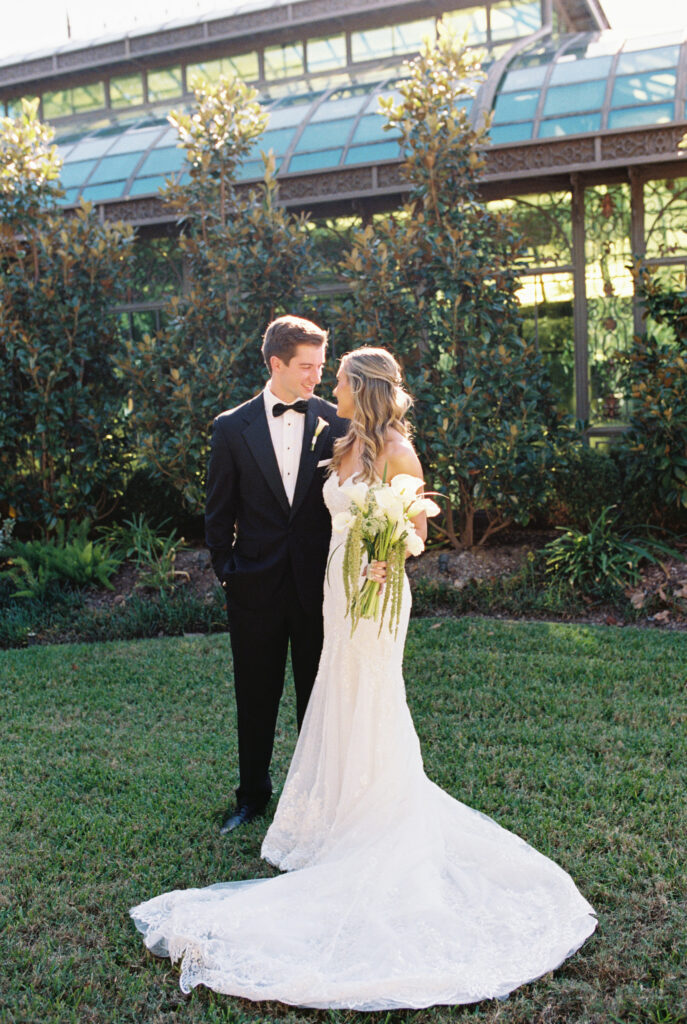 Bride and groom stares at each other behind the conservatory during the fall wedding at The Bryan Museum.