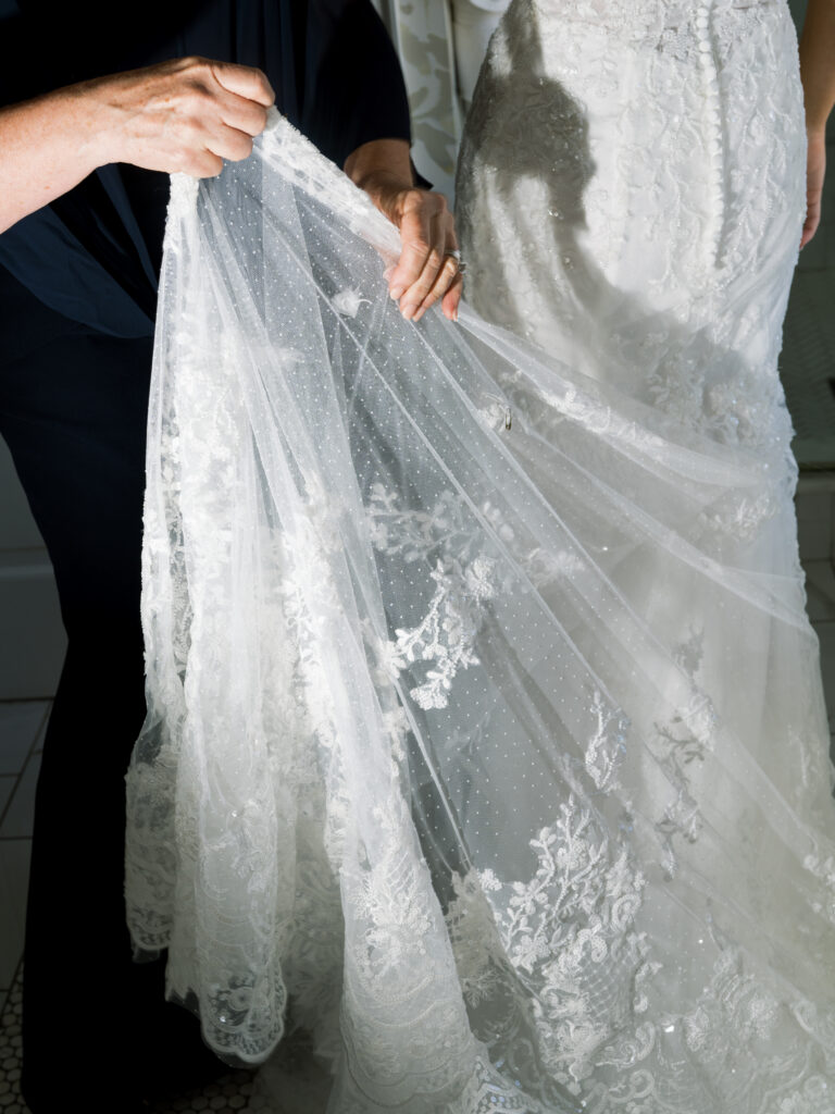 Bride preparing her veil in a light-filled room before her fall wedding ceremony at The Bryan Museum.