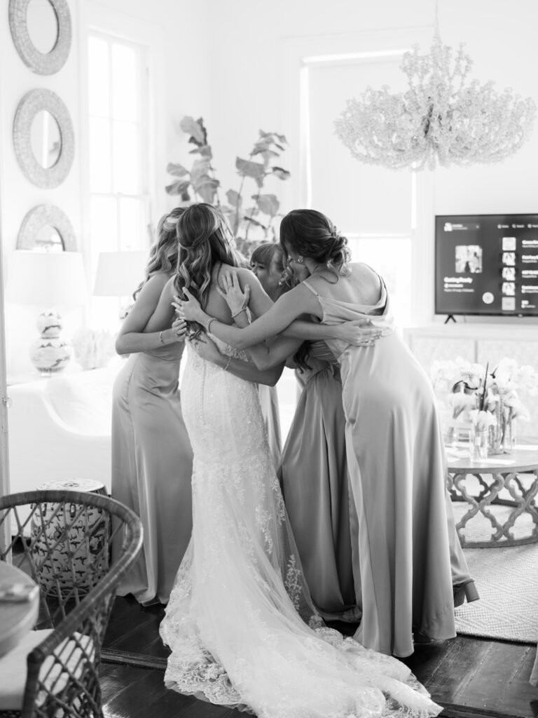 Bride shared intimate hugs with her bridesmaids during a heartfelt first look at a fall wedding at The Bryan Museum.