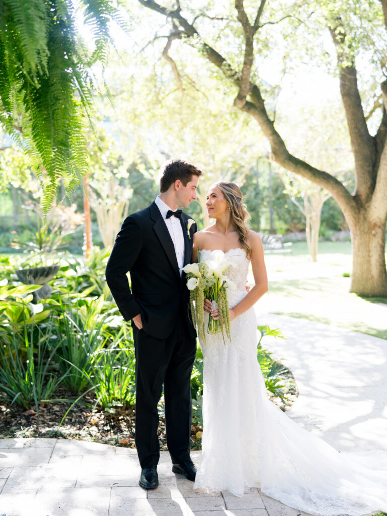 Bride and groom stares at each other beneath the trees during romantic fall wedding at The Bryan Museum.