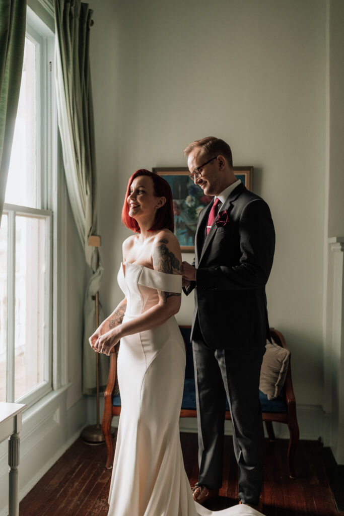 Bride and groom by a window during their Carr Mansion wedding in Galveston, Texas.