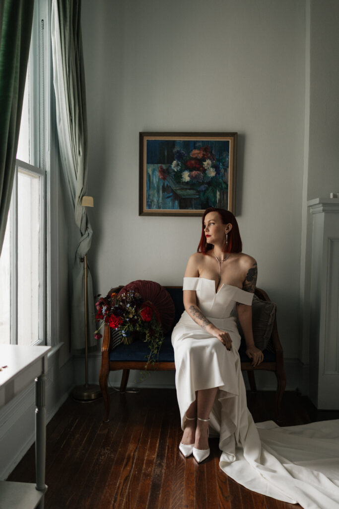 Bride seated by a window during wedding preparations at Carr Mansion in Galveston.