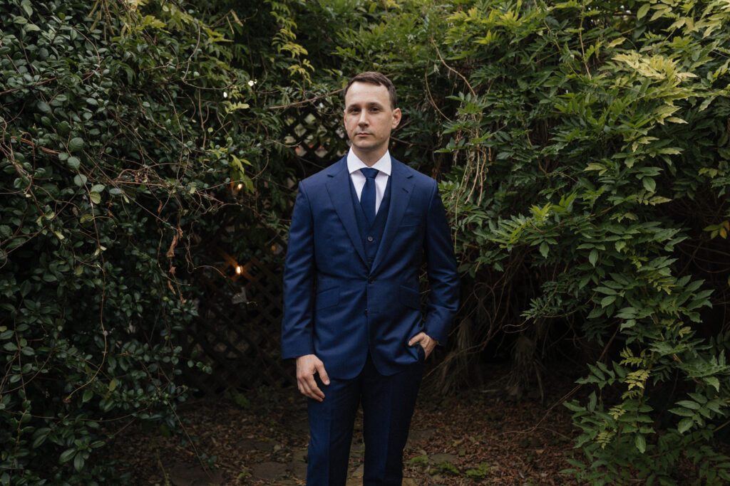 Portrait of groom in navy suit at Carr Mansion wedding venue in Galveston.