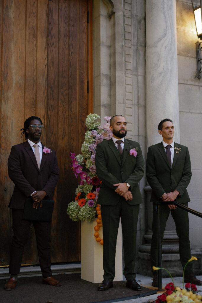 Groom and groomsmen waiting at the ceremony entrance of the Julia Ideson Library wedding.